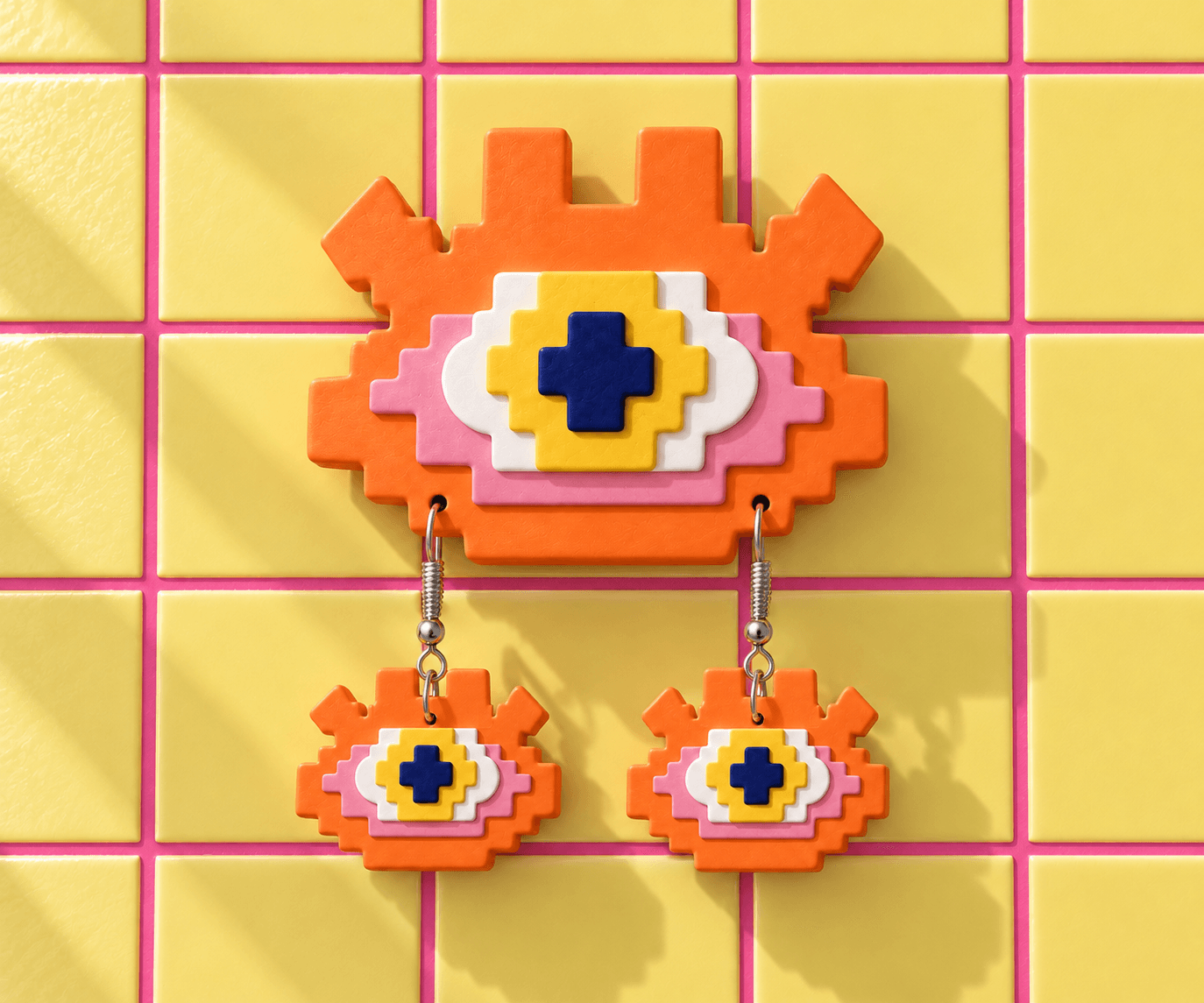 Orange Pixel Eye wall display with pink and white layers, a yellow iris and matching drop earrings against yellow tiles.