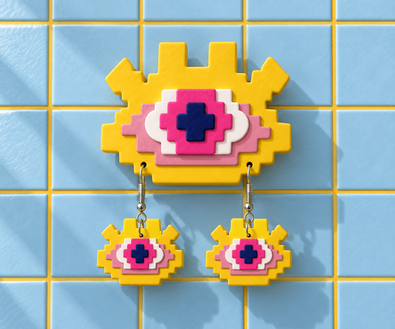 Yellow Pixel Eye wall display with pink and white layers and matching drop earrings against light blue tiles.