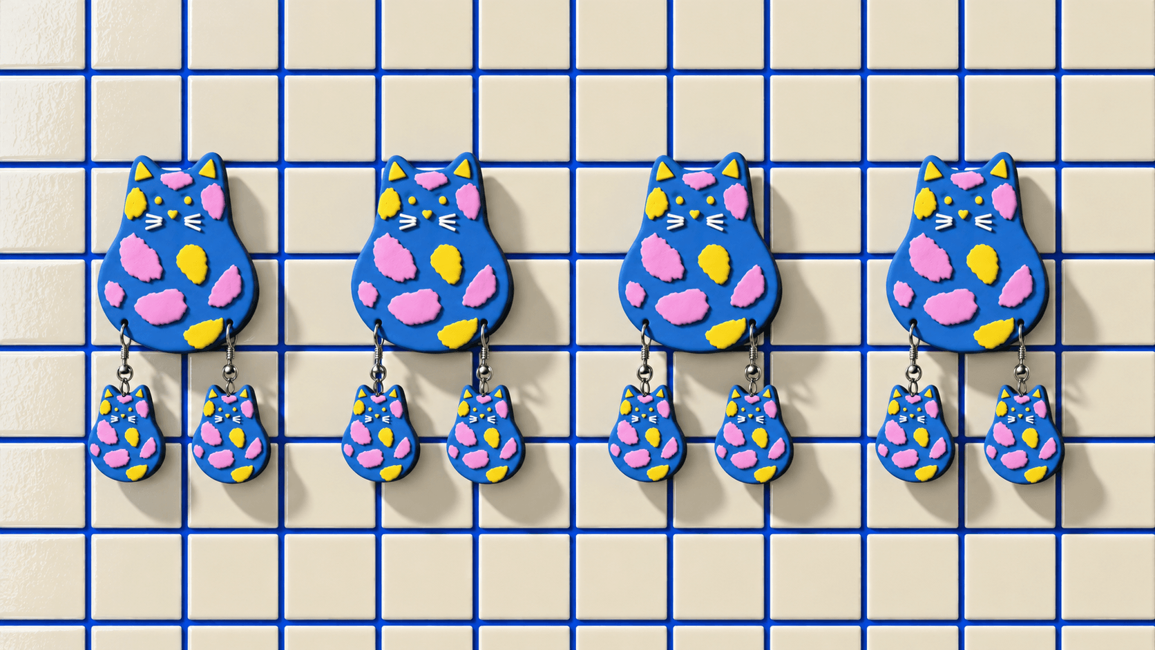 Blue Cat wall displays with matching hanging Cat earrings on cream tiles.
