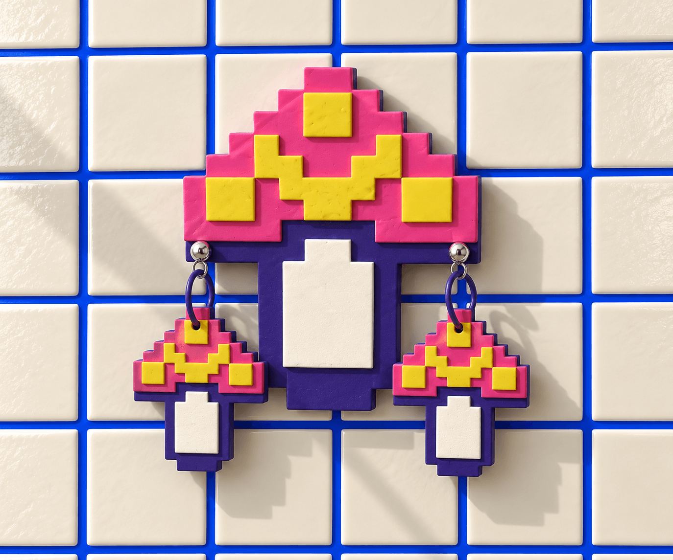 Pink and yellow layered Pixel Mushroom wall display with purple and white details and a matching pair of ball-post drop earrings on white tiles.