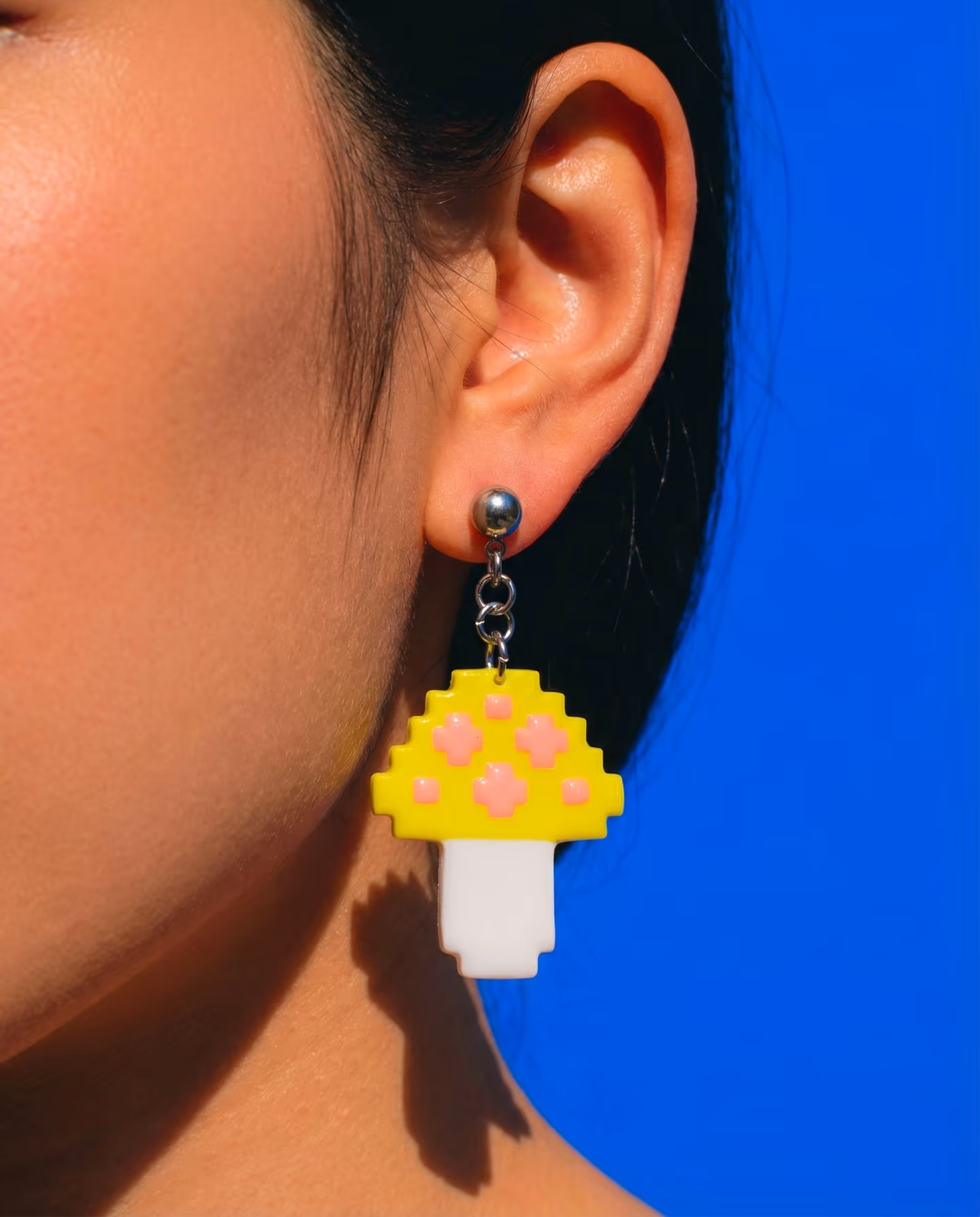 Yellow Pixel Mushroom Drop Earrings in styled context. Build each mushroom as a flat white base with a yellow cap layered on top, then add the pale-pink spots while the clay is st…