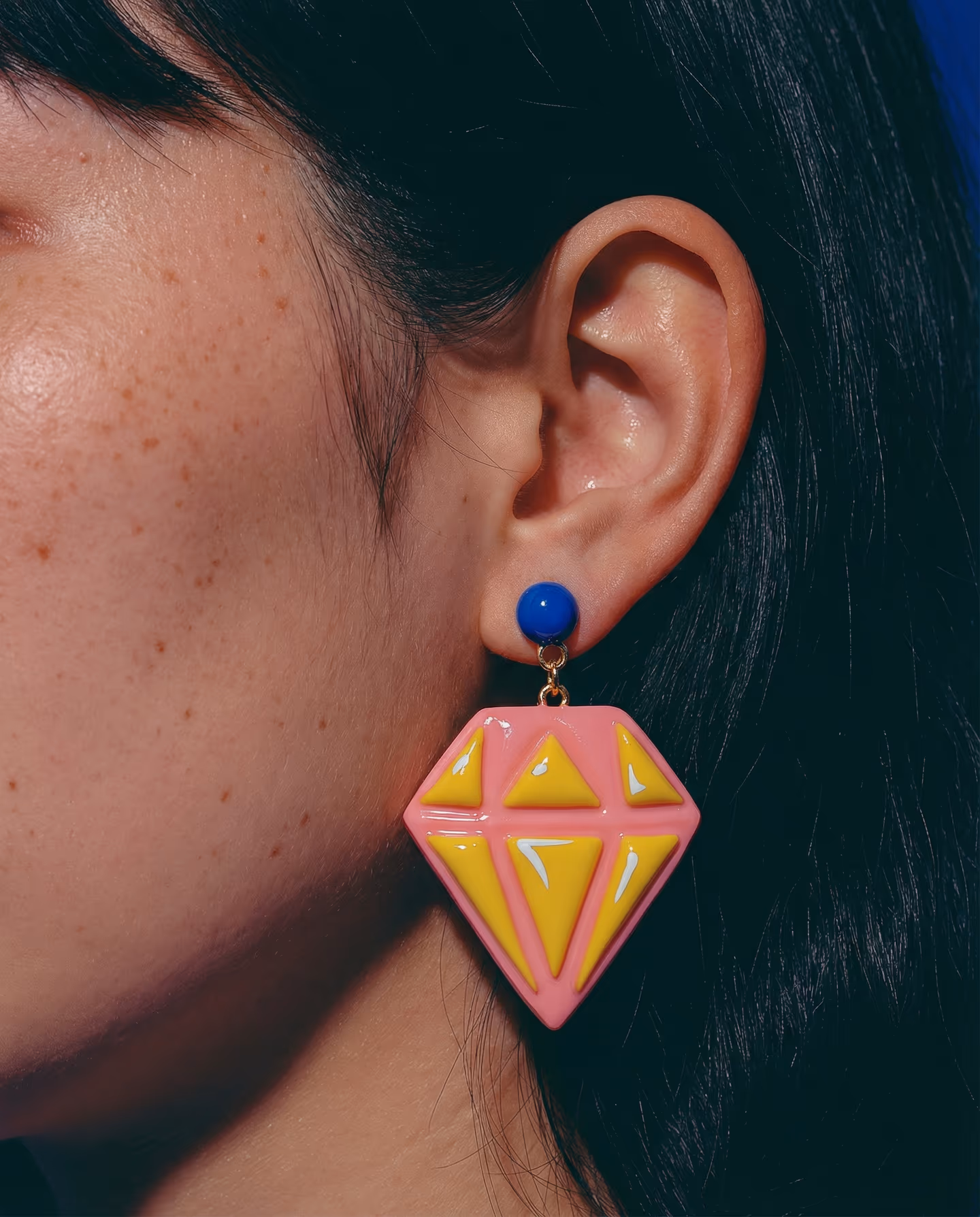 Pink and Yellow Faceted Gem Earrings in styled context. Start with a coral-pink diamond slab and cut the yellow triangle facets to fit inside it, because the pair reads like a fla…