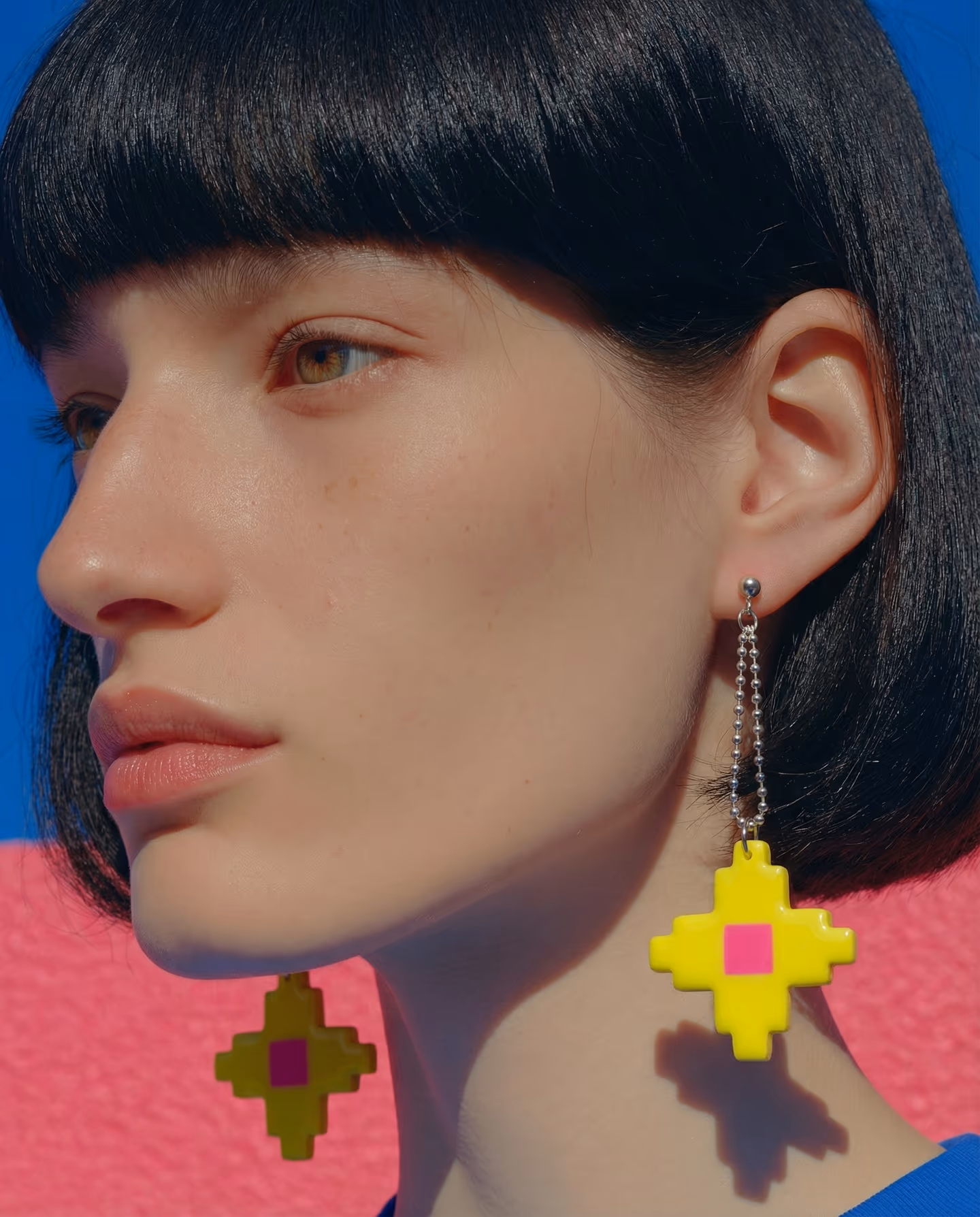 Yellow Pixel Cross Ball-Chain Drops in styled context. Start with the acid-yellow cross plaque and a separate hot-pink center square, because the image pair shows a flat stepped c…