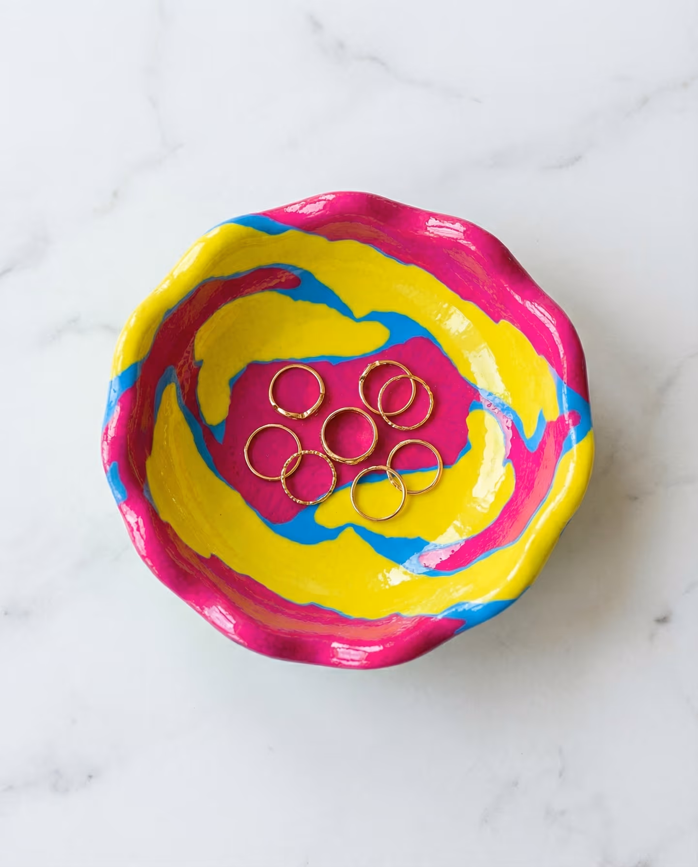 Rainbow Glossy Wavy Edge Trinket Dish in styled context. Build this from a loosely marbled slab, because the image pair shows pooled rainbow color pressed into a shallow dish form…