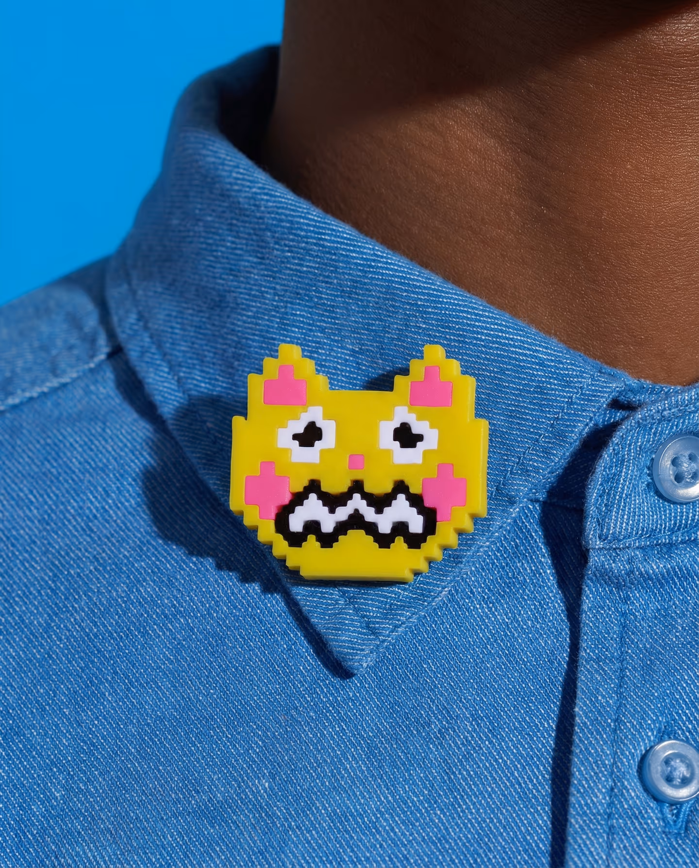 Yellow and Pink Worried Pixel Cat Brooch in styled context. Build this as one flat cat-face plaque with a stepped anxious expression, not as a chunky character head. The product a…