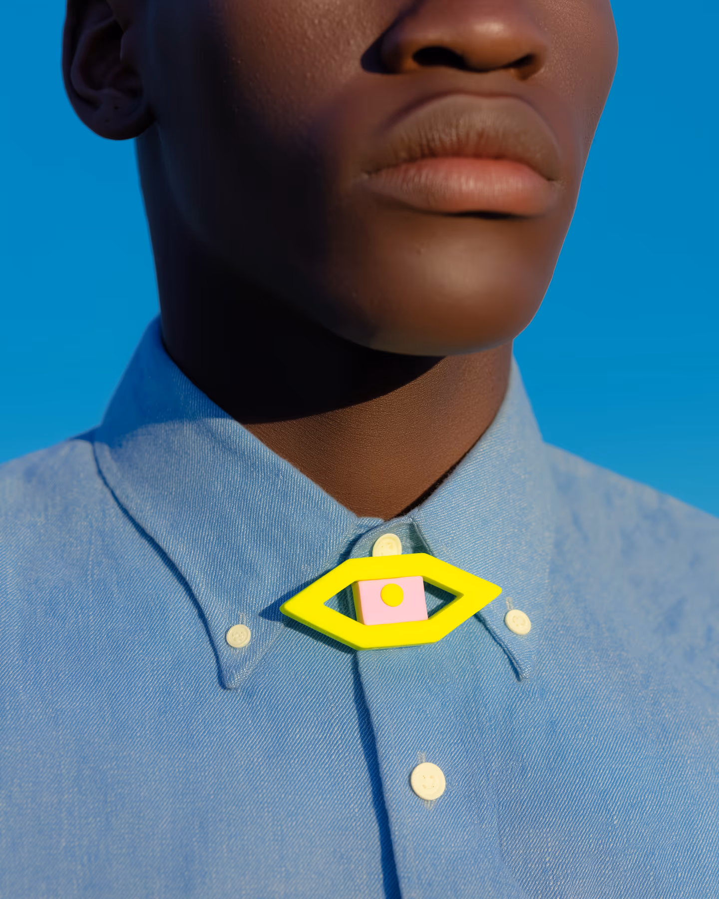 Yellow Diamond Eye Brooch in styled context. Start with the yellow diamond frame first, because the pair reads like a geometric frame around a pink center plaque, not like a field…